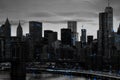 Blue lights shiningÂ in black and white night time cityscape with the Brooklyn Bridge and buildings of Manhattan in New York City